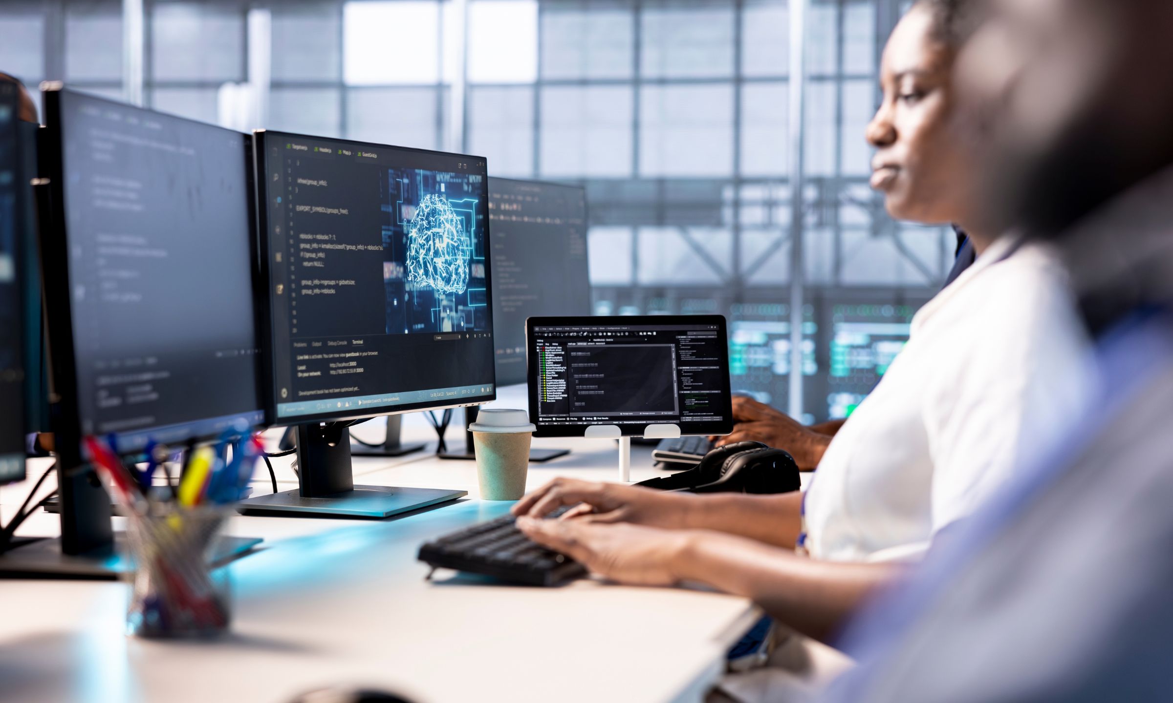 Two people sat at a desk observing their work on a computer screen