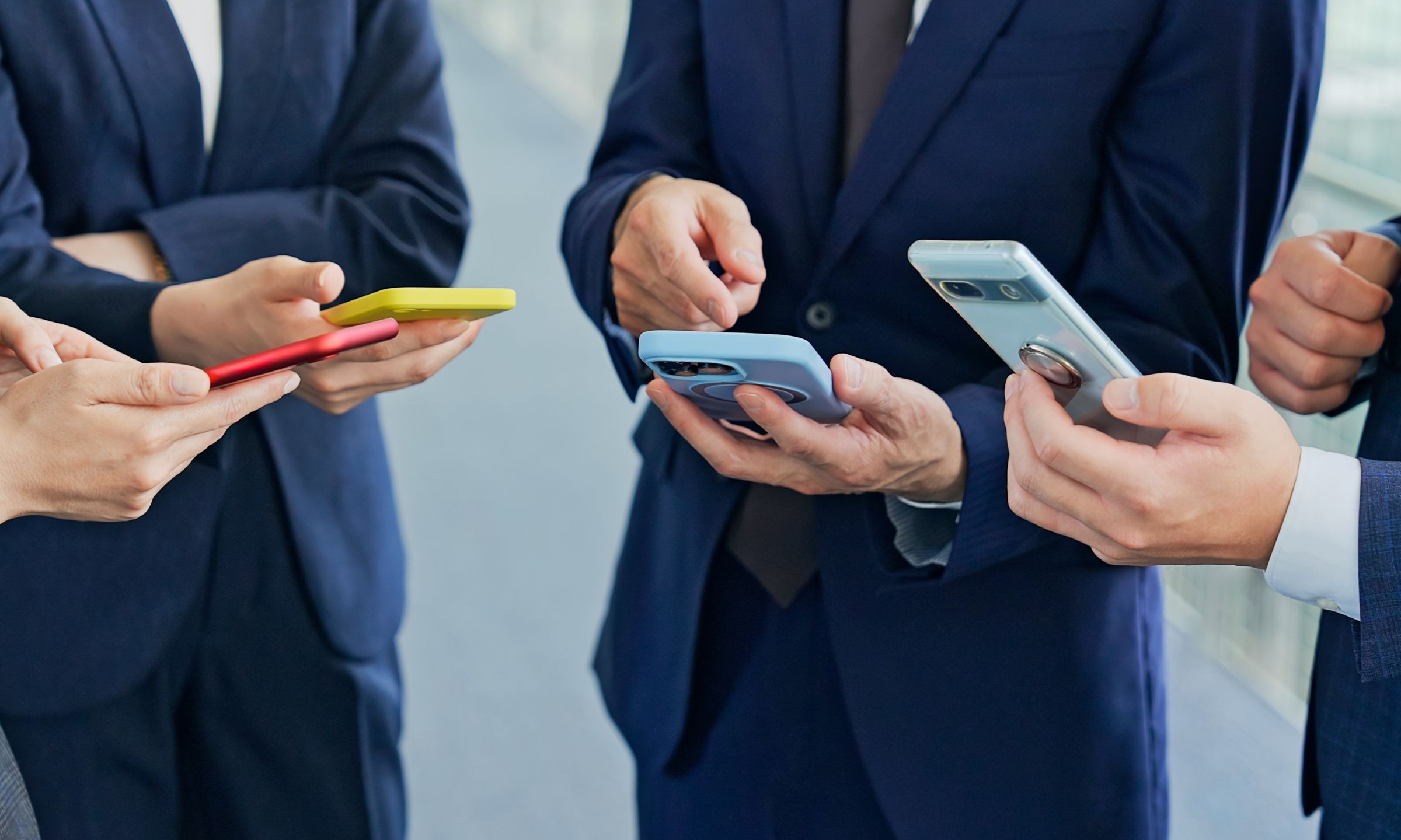 Snapshot of the hands of men in suits holding phones