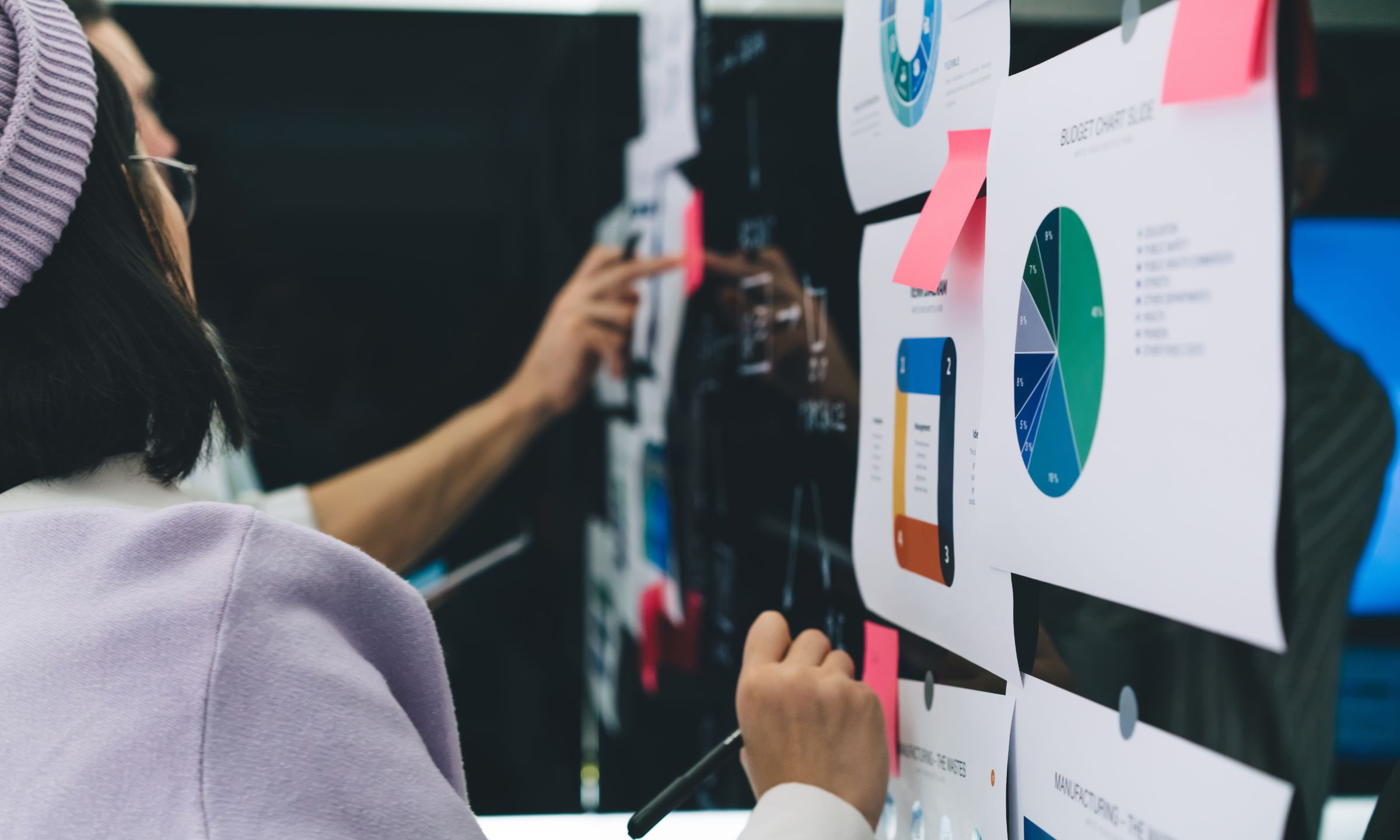 People writing on whiteboard with post it notes