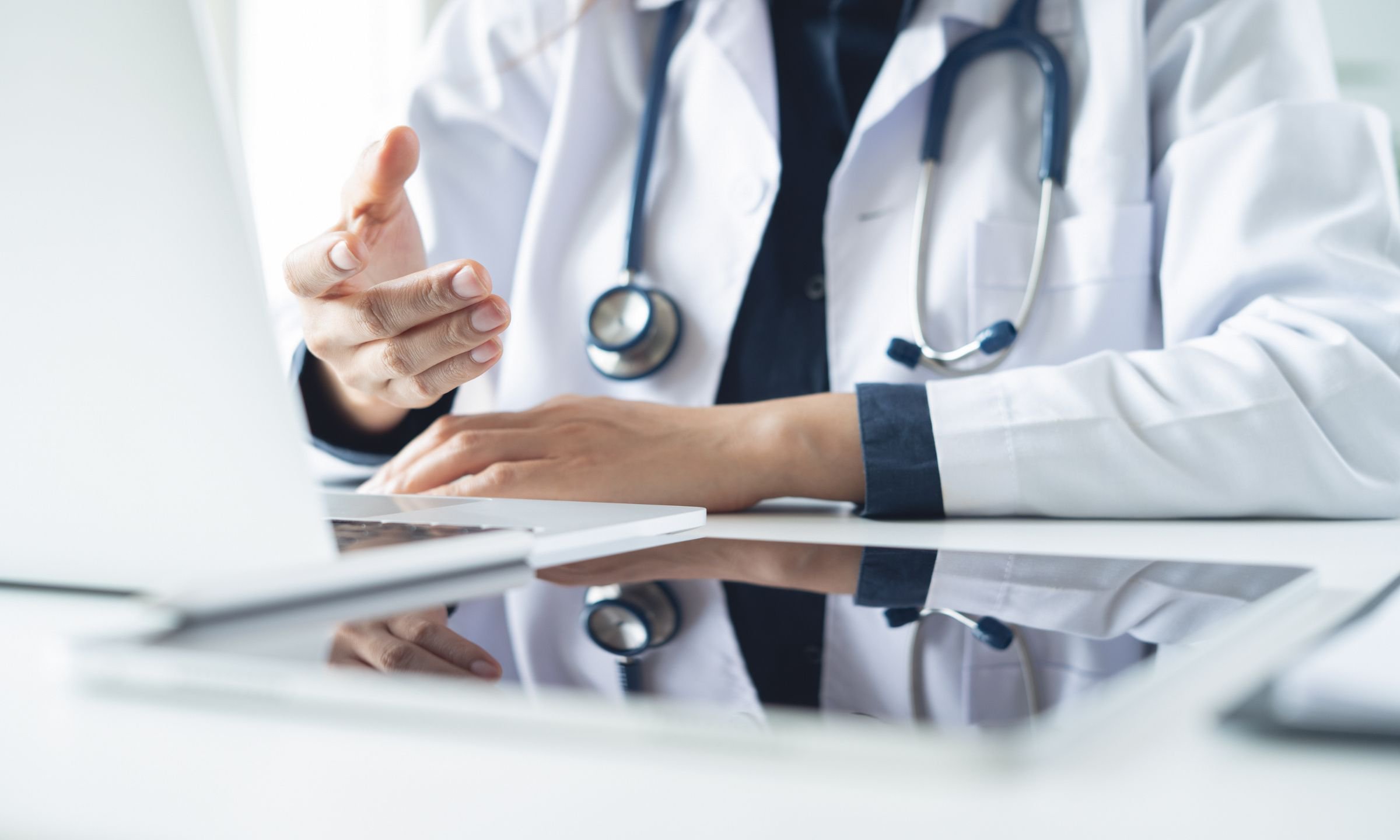 Doctor using a laptop during a patient consultation