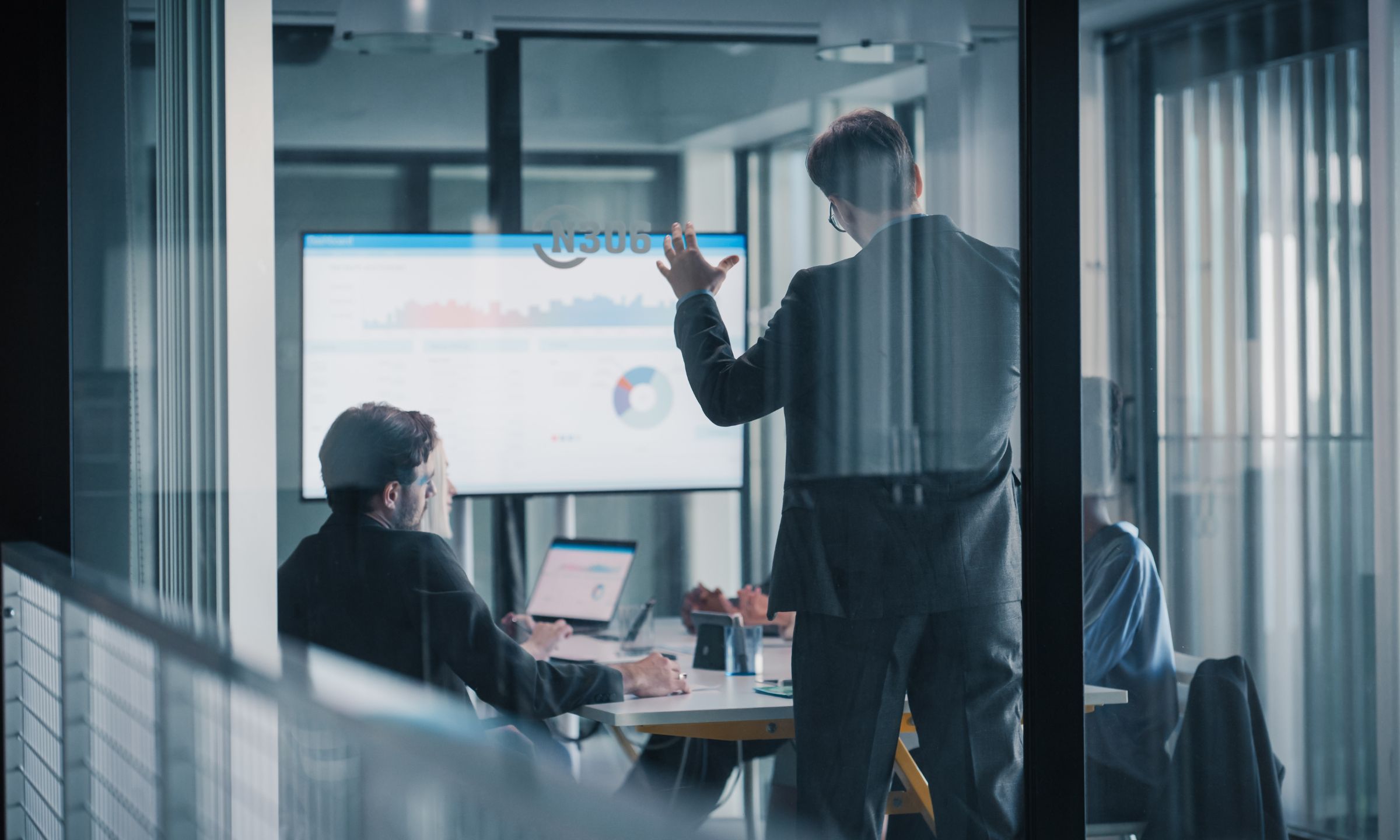 Business professionals reviewing KPI dashboards during a commercial strategy meeting in a modern office.