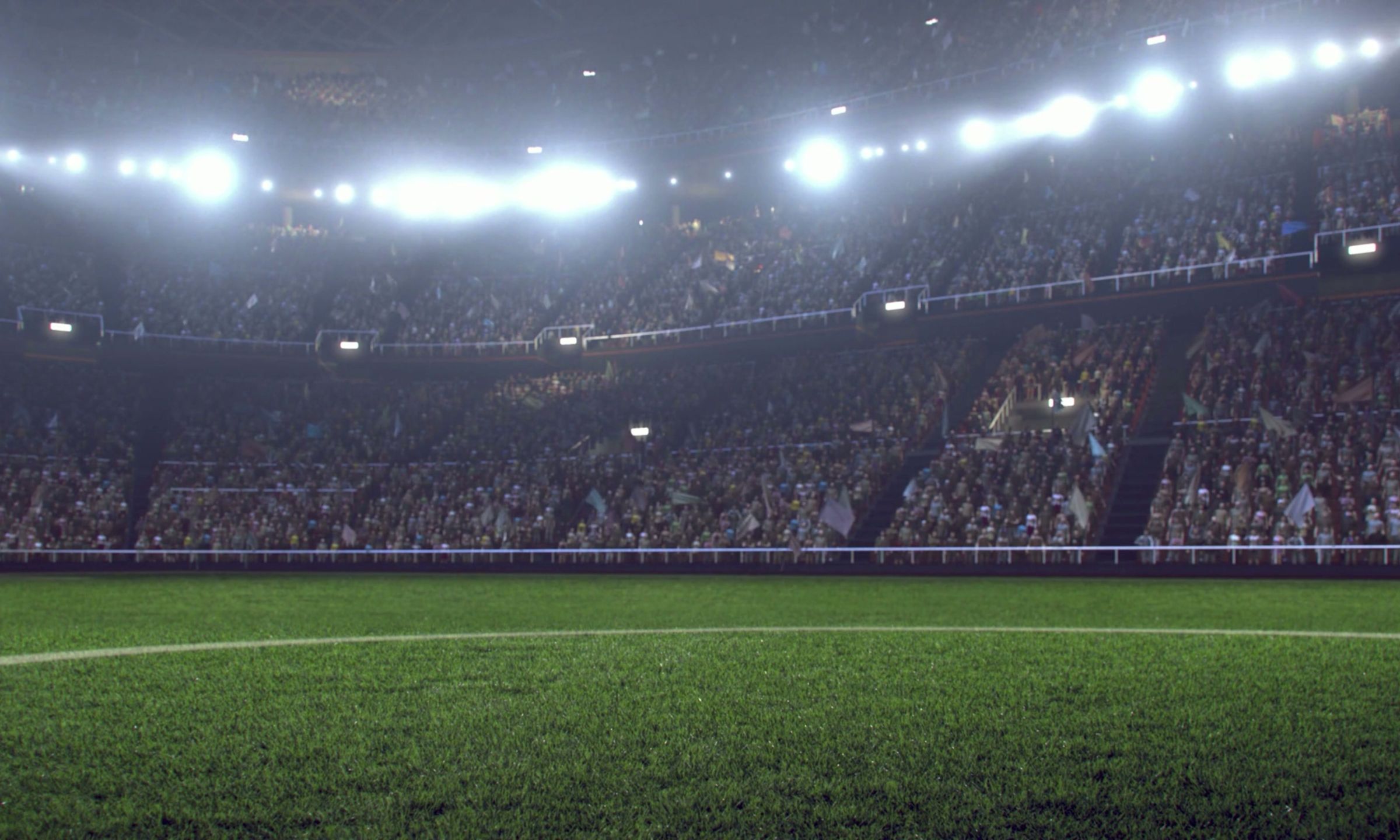 Floodlit football stadium filled with spectators during a live match, viewed from pitch level.