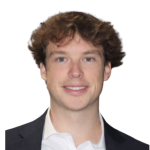 Young person in a blazer smiling at the camera against a white background.