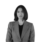 Professional headshot of a women wearing a grey blazer against a white background.