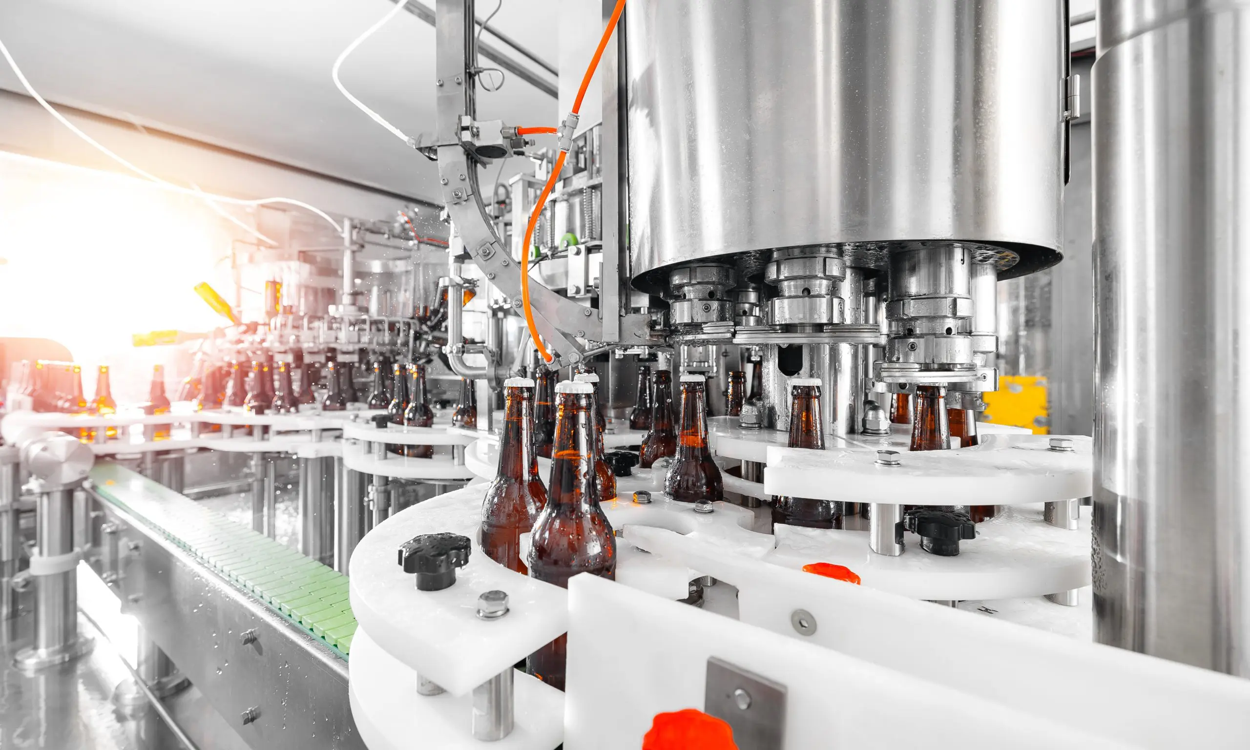 Industrial bottling line filling glass bottles in a modern manufacturing facility.