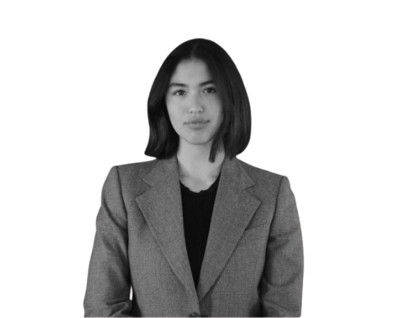 Professional headshot of a women wearing a grey blazer against a white background.