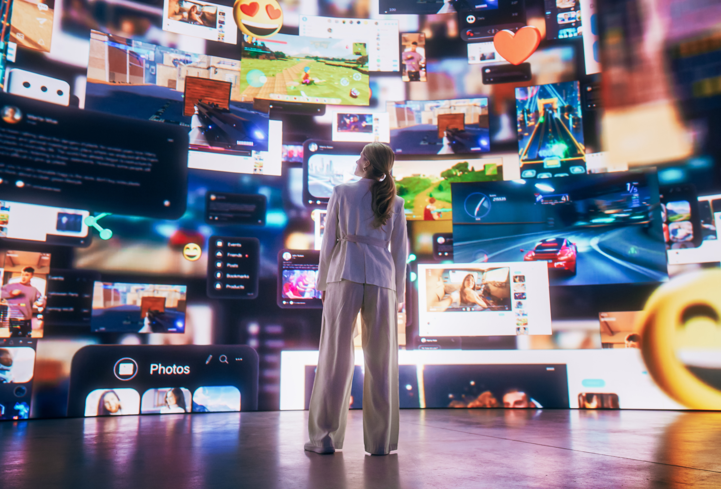 Person standing in front of multiple digital screens displaying data, ideas, and media icons
