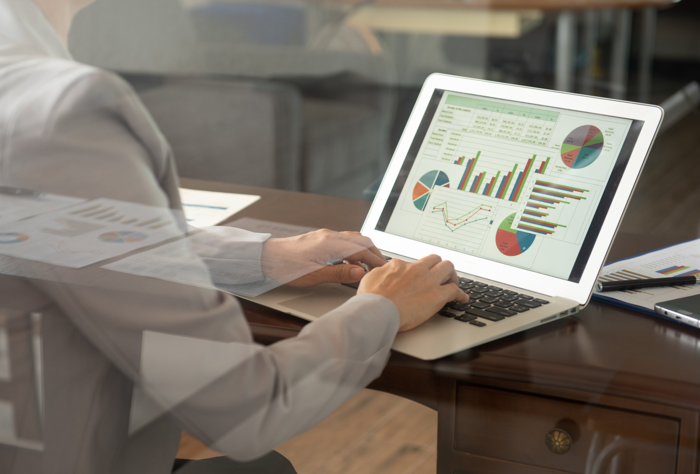 Person analyzing business growth charts and financial insights on a laptop screen in a professional setting