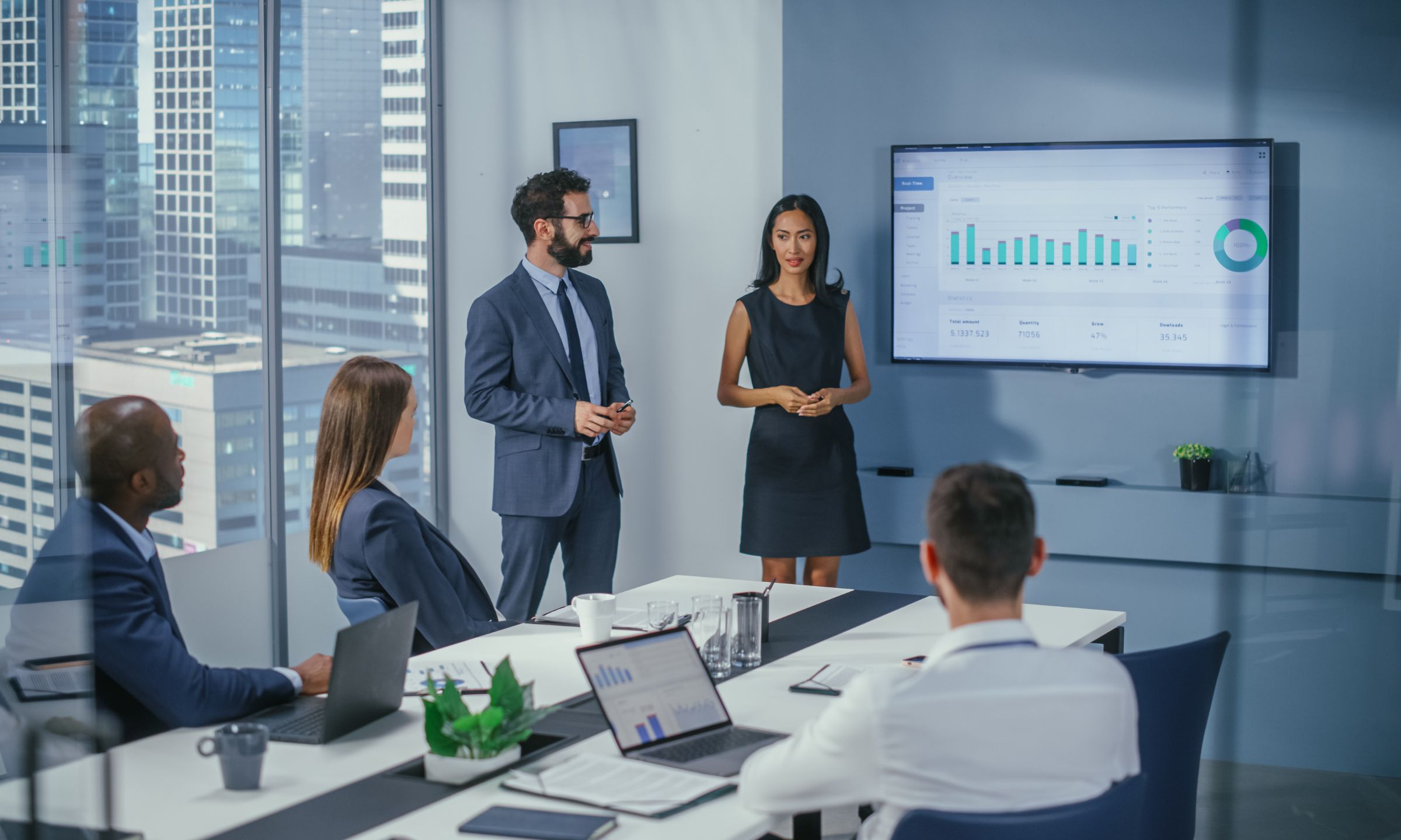 Business team meeting reviewing performance dashboard in conference room